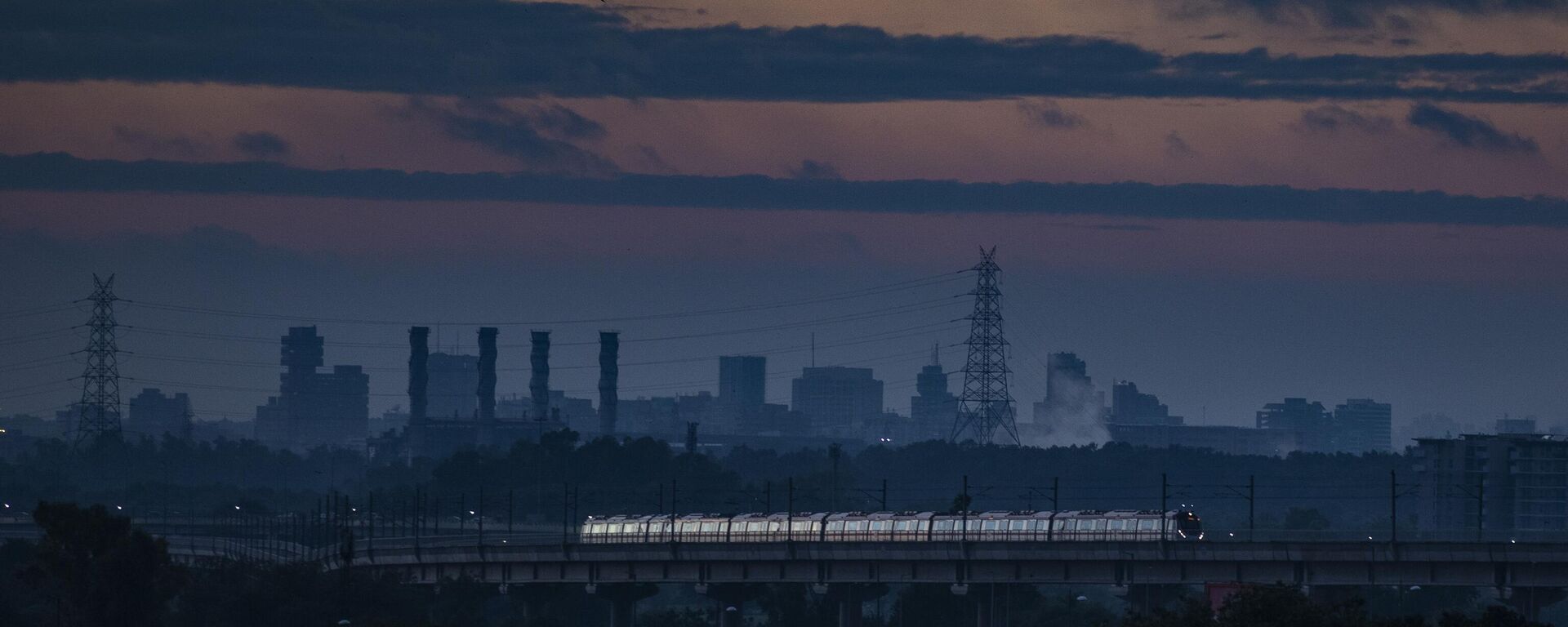 A Delhi Metro train runs in the background of chimneys from defunct Indraprastha Thermal Power Plant Delhi in New Delhi, India - Sputnik भारत, 1920, 17.05.2023