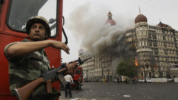 An Indian soldier takes cover as the Taj Mahal hotel burns during gun battle between Indian military and militants inside the hotel in Mumbai, India, Nov. 29, 2008. - Sputnik India