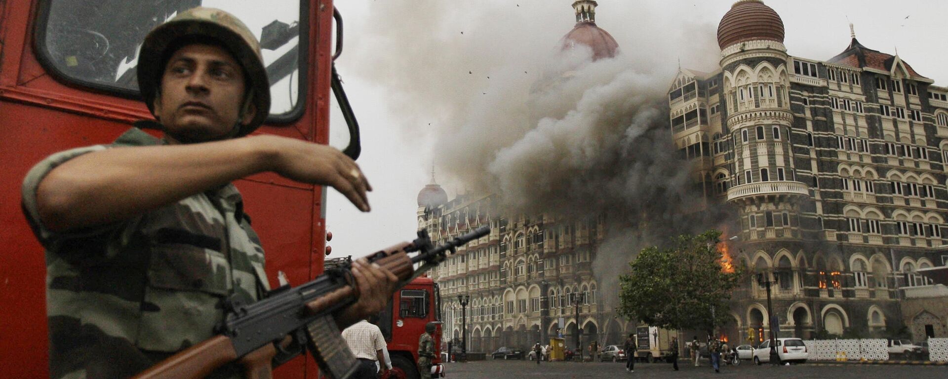 An Indian soldier takes cover as the Taj Mahal hotel burns during gun battle between Indian military and militants inside the hotel in Mumbai, India, Nov. 29, 2008. - Sputnik India, 1920, 21.06.2023