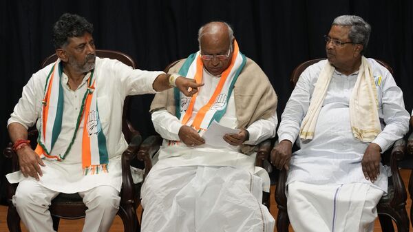Congress party president Mallikarjun Kharge, center, prepares to address a press conference as senior leader Siddaramaiah, right, watches colleague and party's Karnataka state chief D. K. Shivakumar after their win in Karnataka state elections in Bengaluru, India, Saturday, May 13, 2023. - Sputnik India