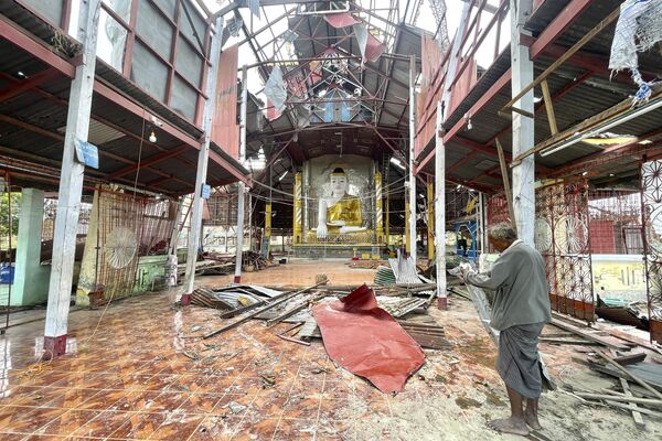 An ethnic Rakhine man stands inside a damaged pagoda to help for repairing roof after Cyclone Mocha in Sittwe township, Rakhine State, Myanmar, Friday, May 19, 2023. - Sputnik India