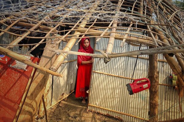 सोमवार, 15 मई, 2023 को बांग्लादेश के कॉक्स बाज़ार में सेंट मार्टिन द्वीप पर चक्रवात मोचा से अपने घर को हुई क्षति की समीक्षा करती  एक महिला। (AP Photo/Al-Imrun Garjon) - Sputnik भारत
