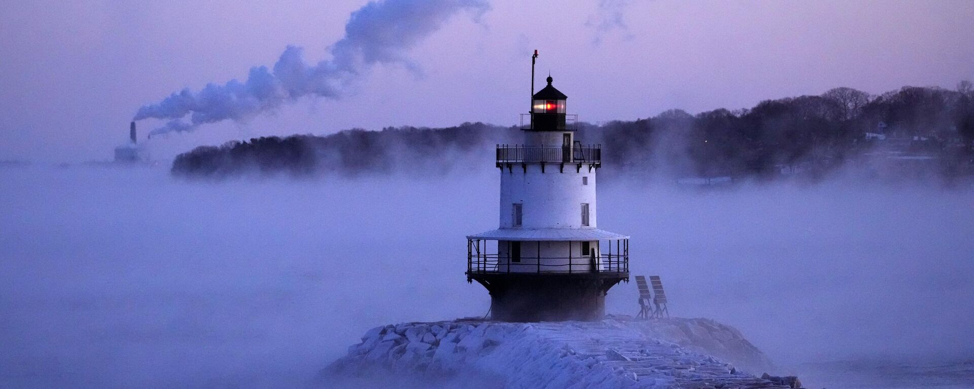 Spring Point Ledge Light is surrounded by arctic sea smoke while emissions from the Wyman Power plant, background, are blown horizontal by the fierce wind, Saturday, Feb. 4, 2023, in South Portland, Maine. - Sputnik भारत, 1920, 03.10.2023
