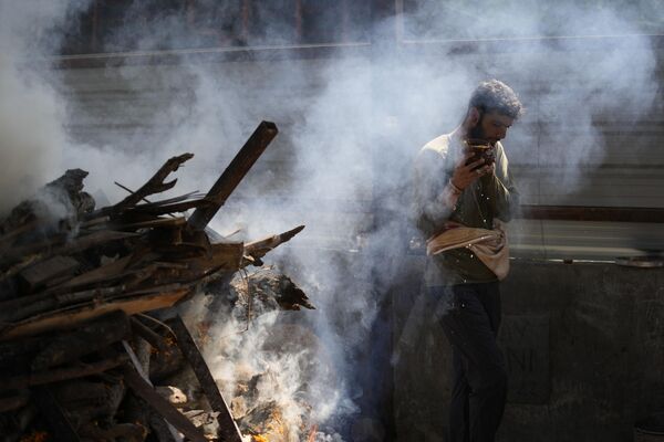 A man performs rituals during a funeral, Jammu, India - Sputnik India