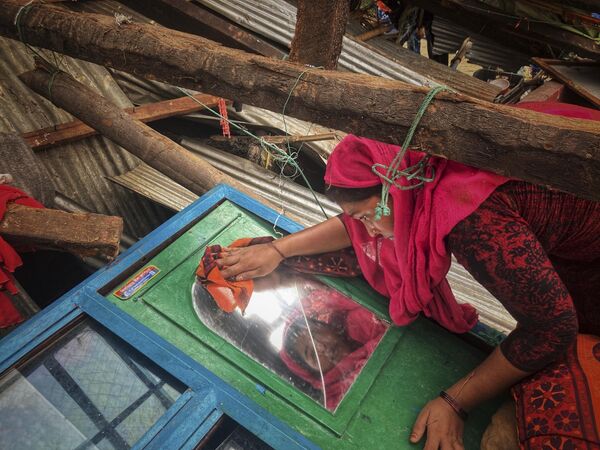 A woman salvages belongings from her home damaged by Cyclone Mocha at Saint Martin island in Cox's Bazar, Bangladesh, Monday, May 15, 2023. - Sputnik India