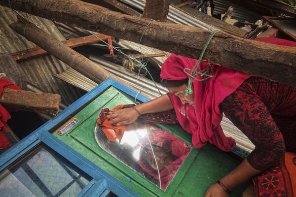 कॉक्स बाजार, बांग्लादेश में सेंट मार्टिन द्वीप पर चक्रवात मोचा द्वारा क्षतिग्रस्त अपने घर से सामानों को निकालती हुई एक महिला, सोमवार, 15 मई, 2023 (AP Photo/Al-Amrun Garjan) - Sputnik भारत