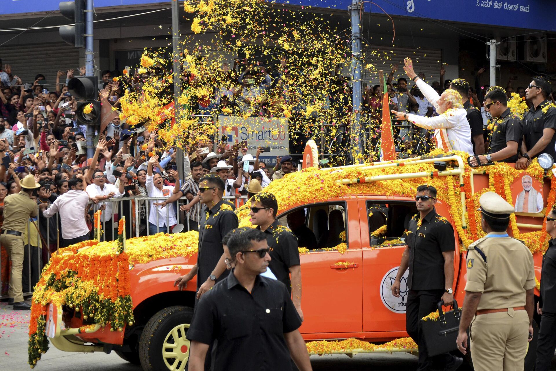 Indian Prime Minister Narendra Modi throws flowers towards the crowd during a road show to campaign for his Bharatiya Janata Party (BJP) ahead of the elections in Bengaluru, India, Sunday, May 7, 2023. - Sputnik भारत, 1920, 31.08.2023