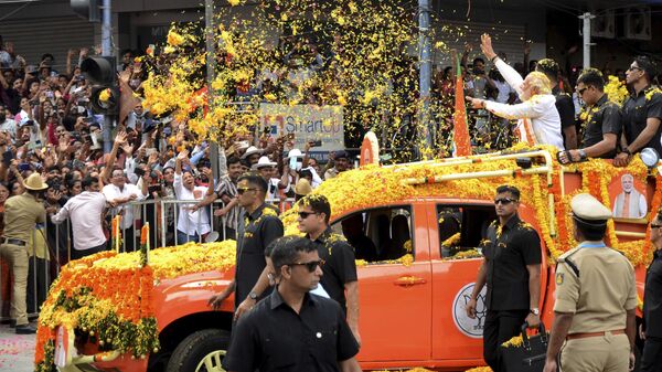 Indian Prime Minister Narendra Modi throws flowers towards the crowd during a road show to campaign for his Bharatiya Janata Party (BJP) ahead of the elections in Bengaluru, India, Sunday, May 7, 2023. - Sputnik India