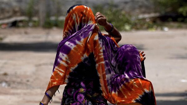 Женщина с ребенком накрывается шалью от жары в Индии  - Sputnik India