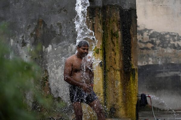 मंगलवार, 16 मई, 2023 को भारत के जम्मू में गर्मी के दिनों में खुद को ठंडा करने के लिए एक आदमी सड़क किनारे पानी के नल से नहा रहा है। (Photo by Channi Anand/AP Photo) - Sputnik भारत