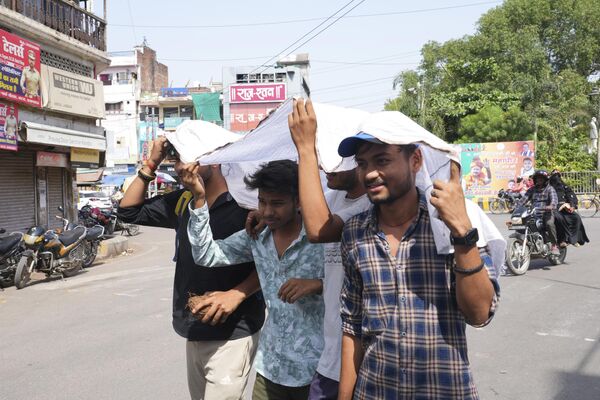 Youth share a piece of cloth to protect themselves from the sun  - Sputnik India