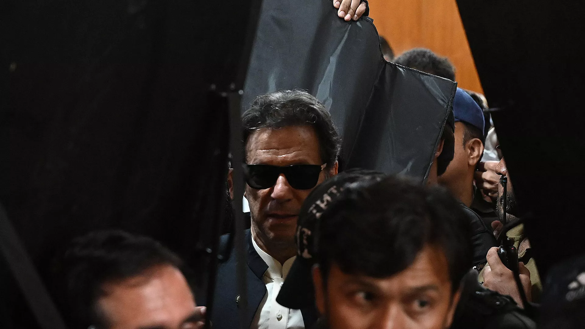 Security personnel with ballistic shields escort former Pakistan's prime minister Imran Khan (C) as he leaves after appearing at the High Court in Lahore on May 19, 2023. Security personnel with ballistic shields escort former Pakistan's prime minister Imran Khan (C) as he leaves after appearing at the High Court in Lahore on May 19, 2023. - Sputnik भारत, 1920, 27.05.2023