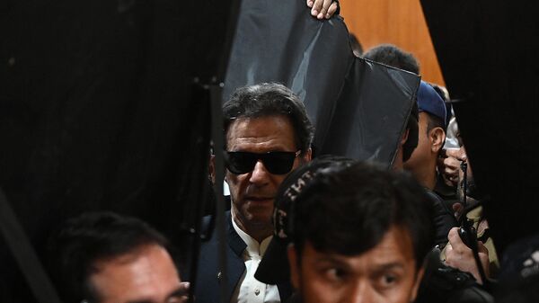 Security personnel with ballistic shields escort former Pakistan's prime minister Imran Khan (C) as he leaves after appearing at the High Court in Lahore on May 19, 2023. - Sputnik भारत