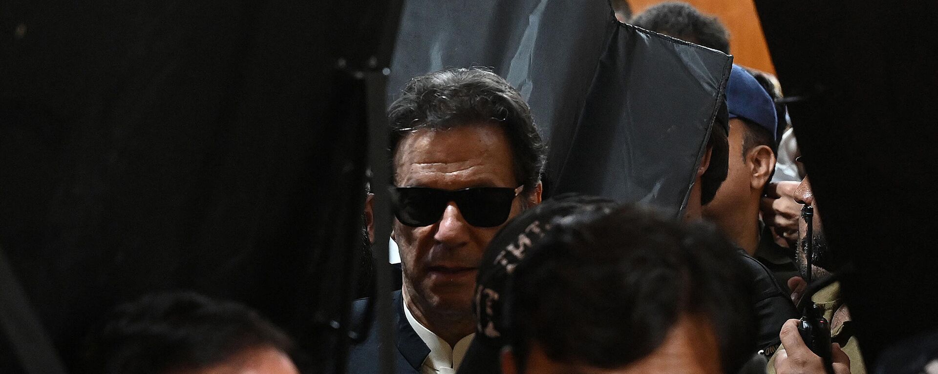 Security personnel with ballistic shields escort former Pakistan's prime minister Imran Khan (C) as he leaves after appearing at the High Court in Lahore on May 19, 2023. - Sputnik India, 1920, 26.05.2023