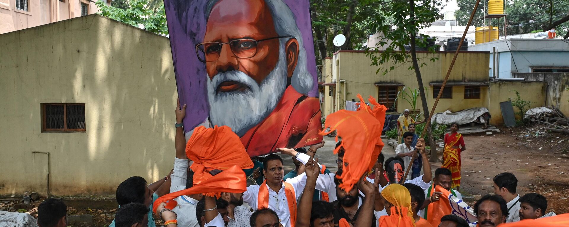 Bharatiya Janata Party (BJP) workers and activists carry a portrait of Indian Prime Minister Narendra Modi as they wait to see Modi during a road rally held by the BJP in Bengaluru on May 6, 2023, ahead of the Karnataka Assembly election. - Sputnik भारत, 1920, 24.05.2023