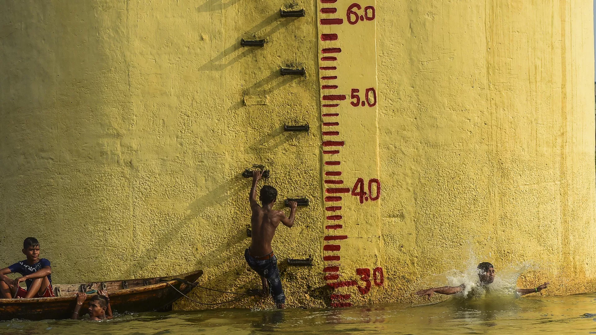 Bangladeshi youths take a bath in the Buriganga River during a hot summer day in Dhaka on June 10, 2019.