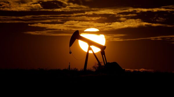 In this Wednesday, April 8, 2020, file photo, the sun sets behind an idle pump jack near Karnes City, Texas. Demand for oil continues to fall due to the new coronavirus outbreak. - Sputnik India