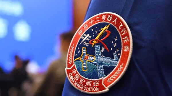 A staff member of the Jiuquan Satellite Launch Centre wears the logo of China's new space station during a press conference about the first crewed mission to the station, scheduled for June 17, at the Jiuquan Satellite Launch Centre in the Gobi desert in northwest China on June 16, 2021. - Sputnik भारत