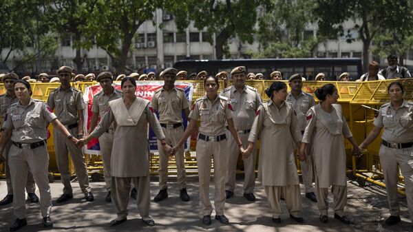 Delhi police personnel stand guard in front of police barricade as supporters of opposition Congress party protest against India's wrestling federation chief over allegations of sexual harassment in New Delhi, India, Thursday, June 1, 2023. - Sputnik भारत