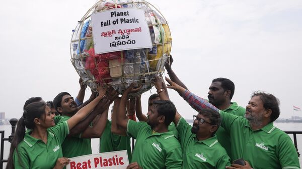 Members of a non-governmental organization display a model of a globe filled with plastic during a demonstration to create awareness on plastic pollution on the eve of World Environment Day in Hyderabad, India, Sunday, June 4, 2023. - Sputnik India
