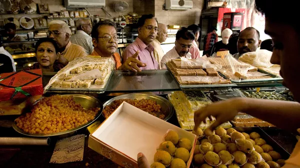 People buy sweets ahead of festival season from a sweet shop, in New Delhi, India, Tuesday, Sept. 30, 2008. For thousands of years, Dilwali celebrations have had a sweet embrace on India. - Sputnik India