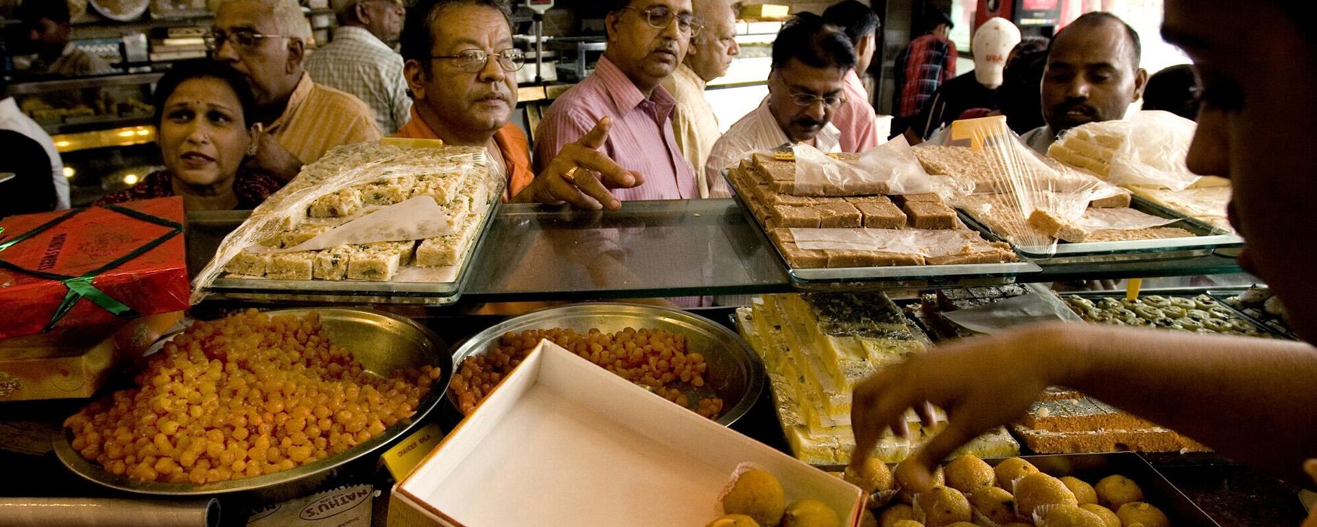 People buy sweets ahead of festival season from a sweet shop, in New Delhi, India, Tuesday, Sept. 30, 2008. For thousands of years, Dilwali celebrations have had a sweet embrace on India. - Sputnik India, 1920, 09.06.2023