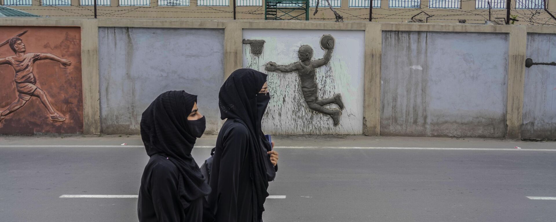 Muslim students walk outside wall of a newly renovated sports stadium ahead of G20 tourism working group meeting in Srinagar, Tuesday, May 16, 2023. - Sputnik India, 1920, 09.06.2023