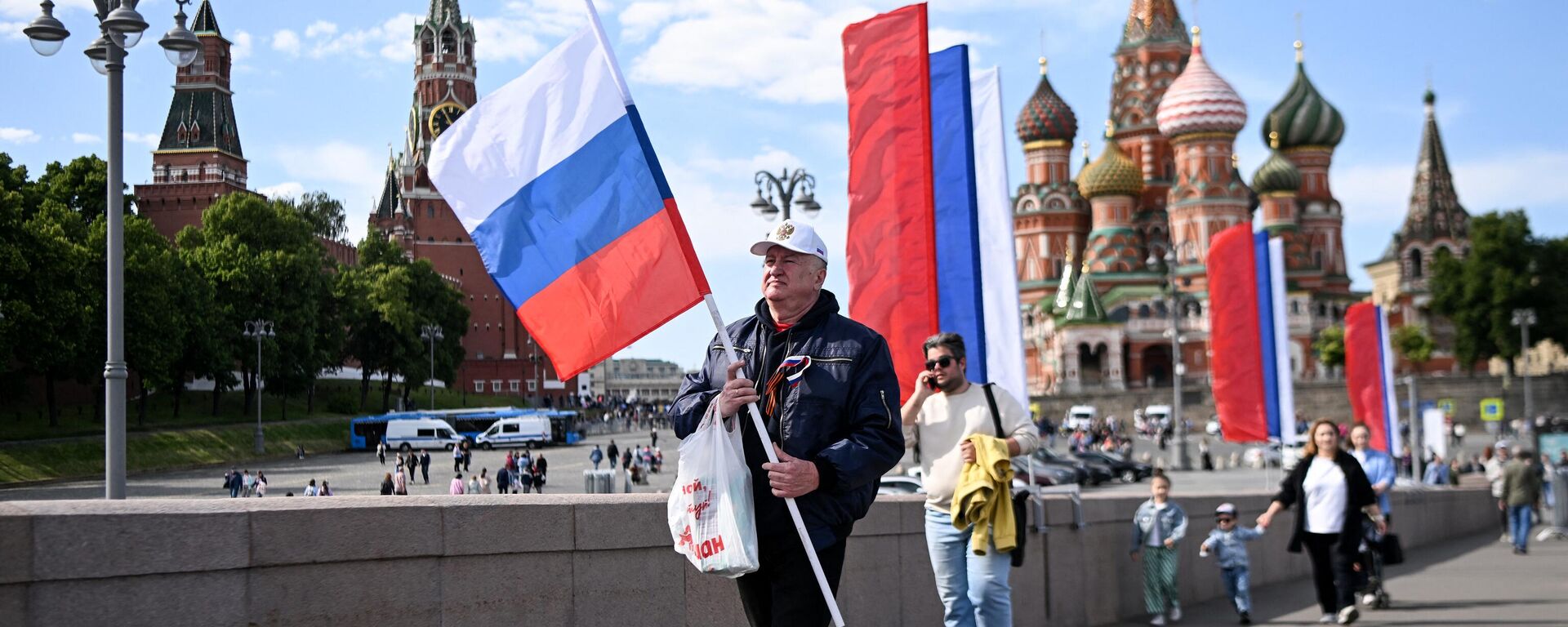 Мужчина с российским национальным флагом у Кремля в центре Москвы - Sputnik India, 1920, 24.06.2023