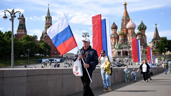 Мужчина с российским национальным флагом у Кремля в центре Москвы - Sputnik India