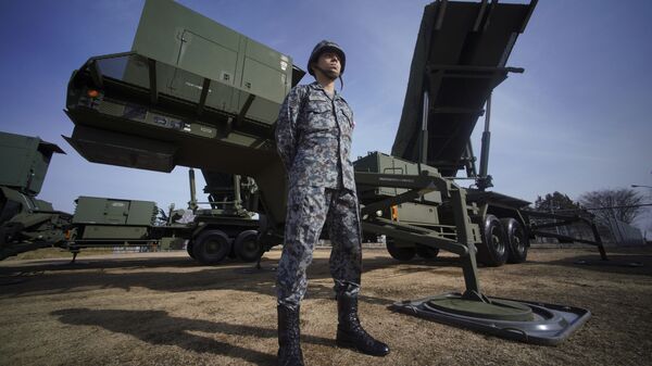 A member of Japan Ground Self-Defense Force stands guard next to a surface-to-air Patriot Advanced Capability-3 (PAC-3) missile interceptor launcher vehicle - Sputnik India