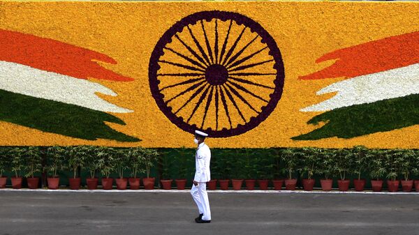 An Indian navy sailor walks past the national flag emblem during Independence Day celebrations at the historic 17th century Red Fort in New Delhi, India, Sunday, Aug. 15, 2021 - Sputnik भारत