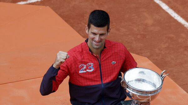 Serbia's Novak Djokovic holds the trophy as he celebrates winning the men's singles final match of the French Open tennis tournament against Norway's Casper Ruud in three sets, 7-6, (7-1), 6-3, 7-5, at the Roland Garros stadium in Paris, Sunday, June 11, 2023. - Sputnik India