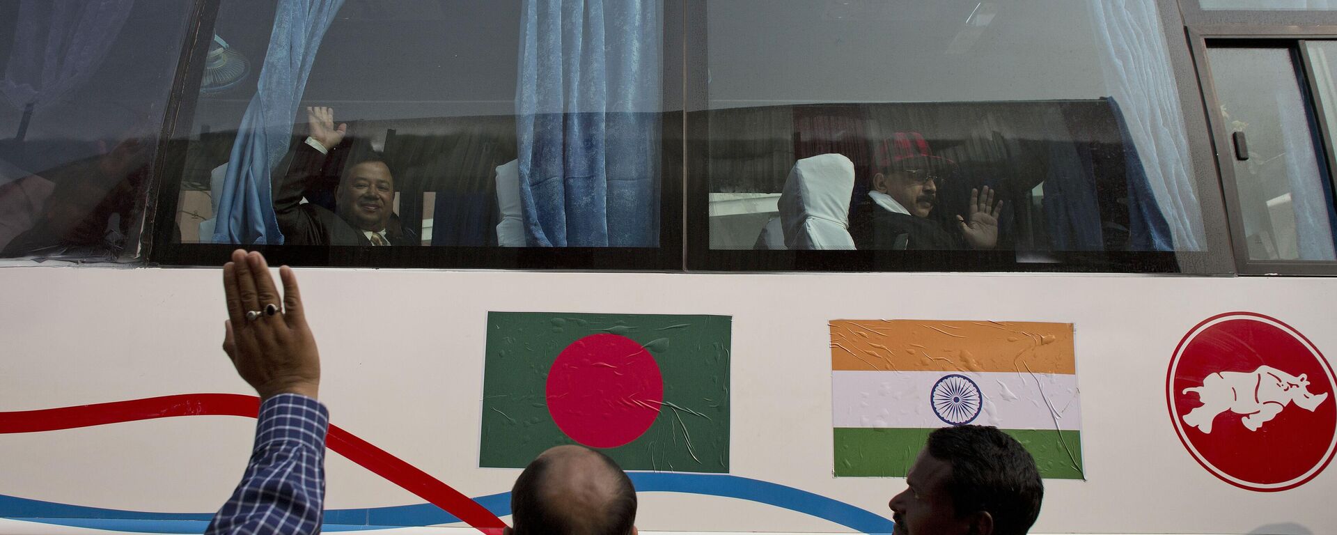 Passengers wave from inside a bus on a trial run from Gauhati to Dhaka in Bangladesh, in Gauhati, India - Sputnik India, 1920, 08.06.2024