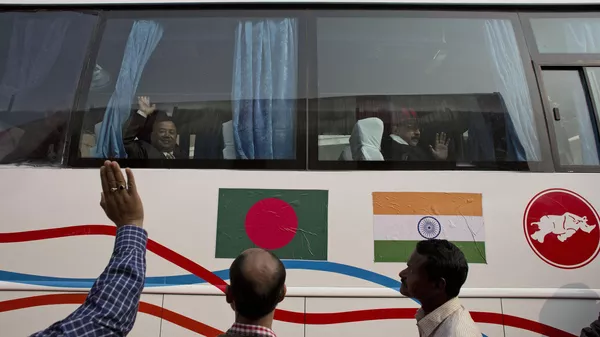 Passengers wave from inside a bus on a trial run from Gauhati to Dhaka in Bangladesh, in Gauhati, India - Sputnik India