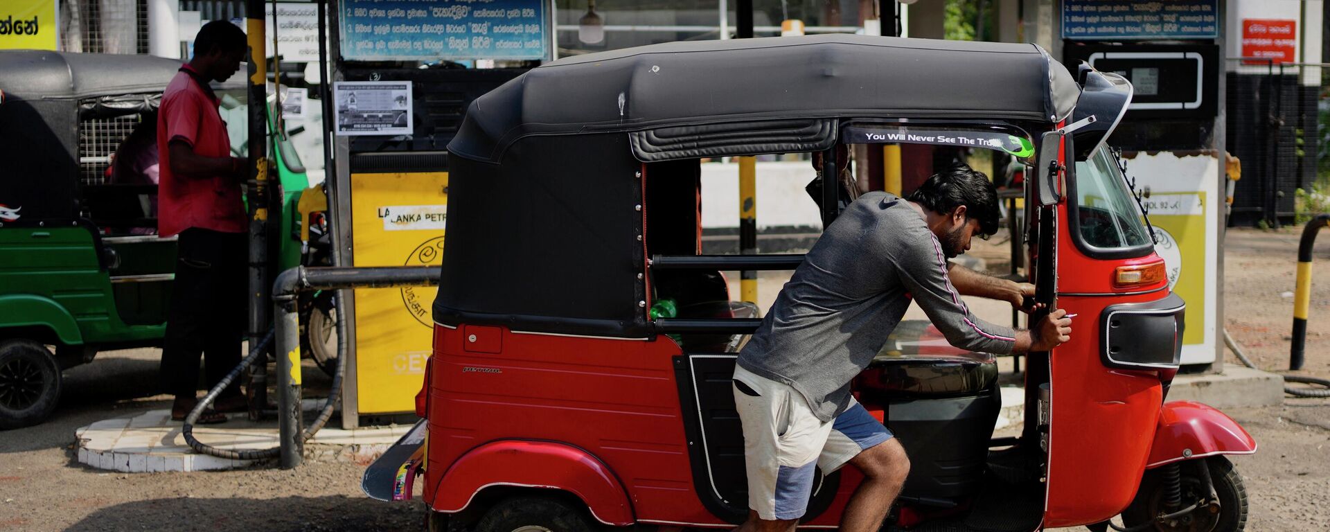 A man pushes his autorickshaw to a fuel station in Colombo, Sri Lanka, Wednesday, July 27, 2022. - Sputnik India, 1920, 15.06.2023
