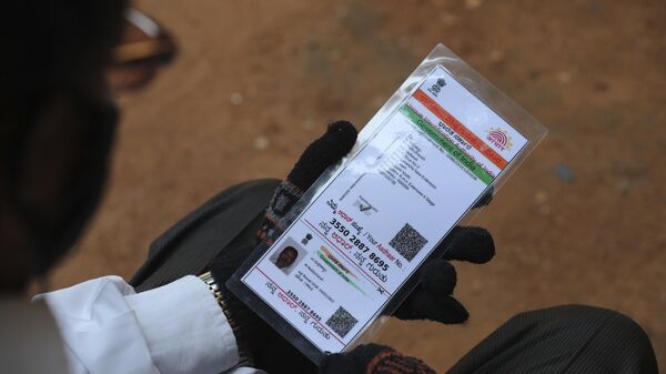 A man waiting to get inoculated against the coronavirus holds his Aadhaar, a government issued identification document at a vaccination camp for those above age 45 being held in the premises of a school in Bengaluru, India, Wednesday, May 26, 2021. - Sputnik India