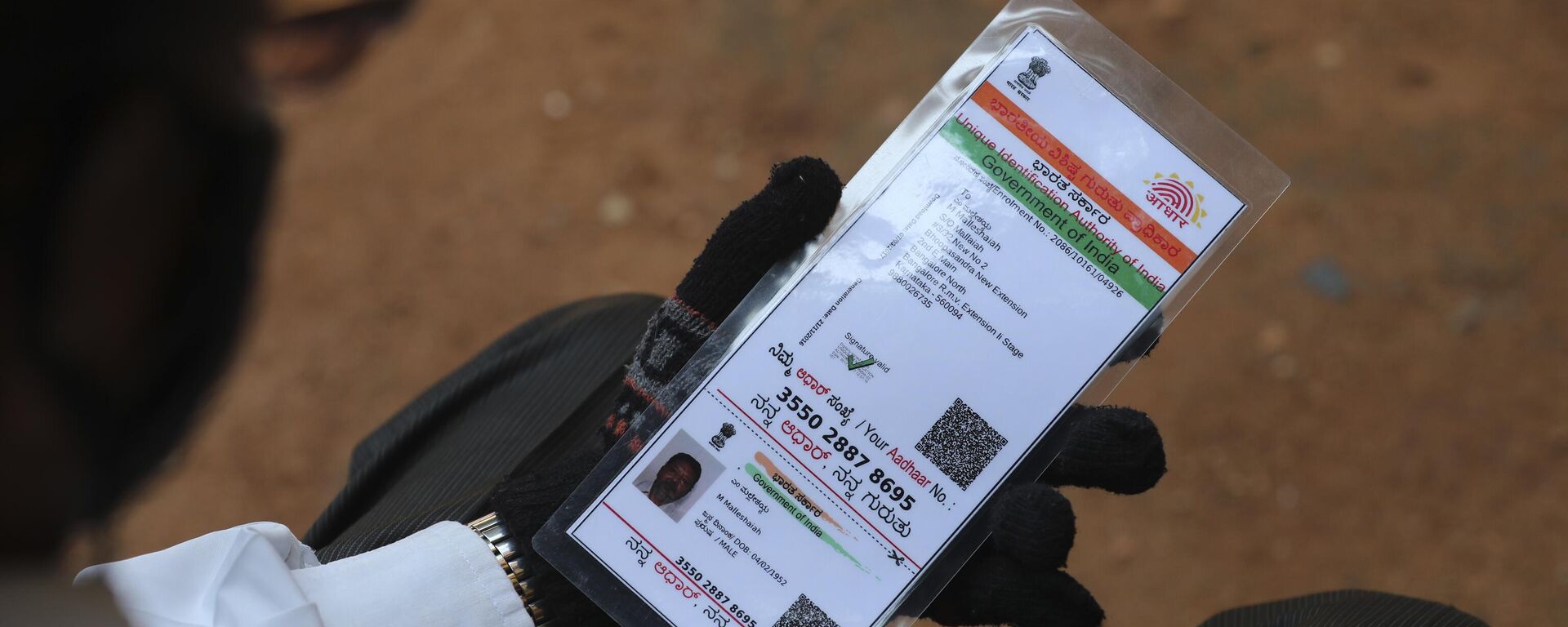 A man waiting to get inoculated against the coronavirus holds his Aadhaar, a government issued identification document at a vaccination camp for those above age 45 being held in the premises of a school in Bengaluru, India, Wednesday, May 26, 2021. - Sputnik India, 1920, 15.06.2023