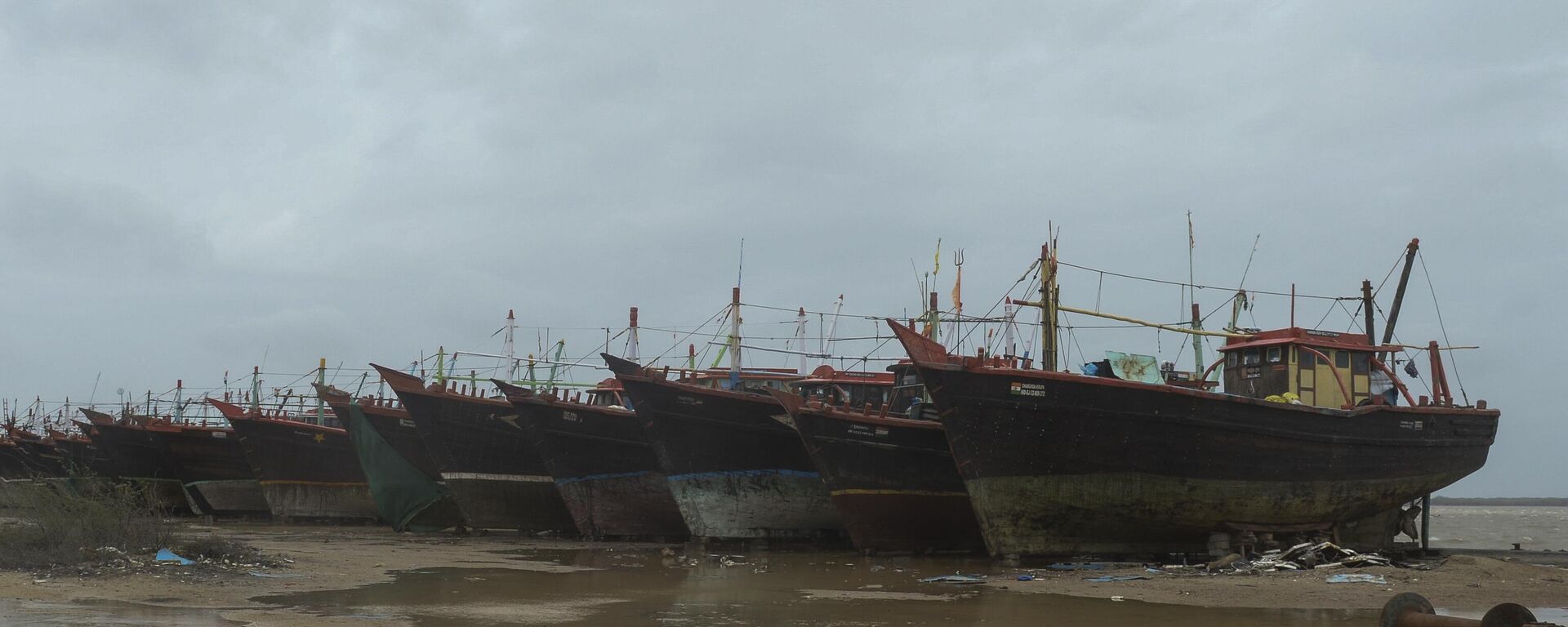 Fishing boats are seen secured on a concrete embankment at Jakhau Port of Kutch district in Gujarat state on June 14, 2023, ahead of cyclone Biparjoy landfall. - Sputnik भारत, 1920, 19.06.2023