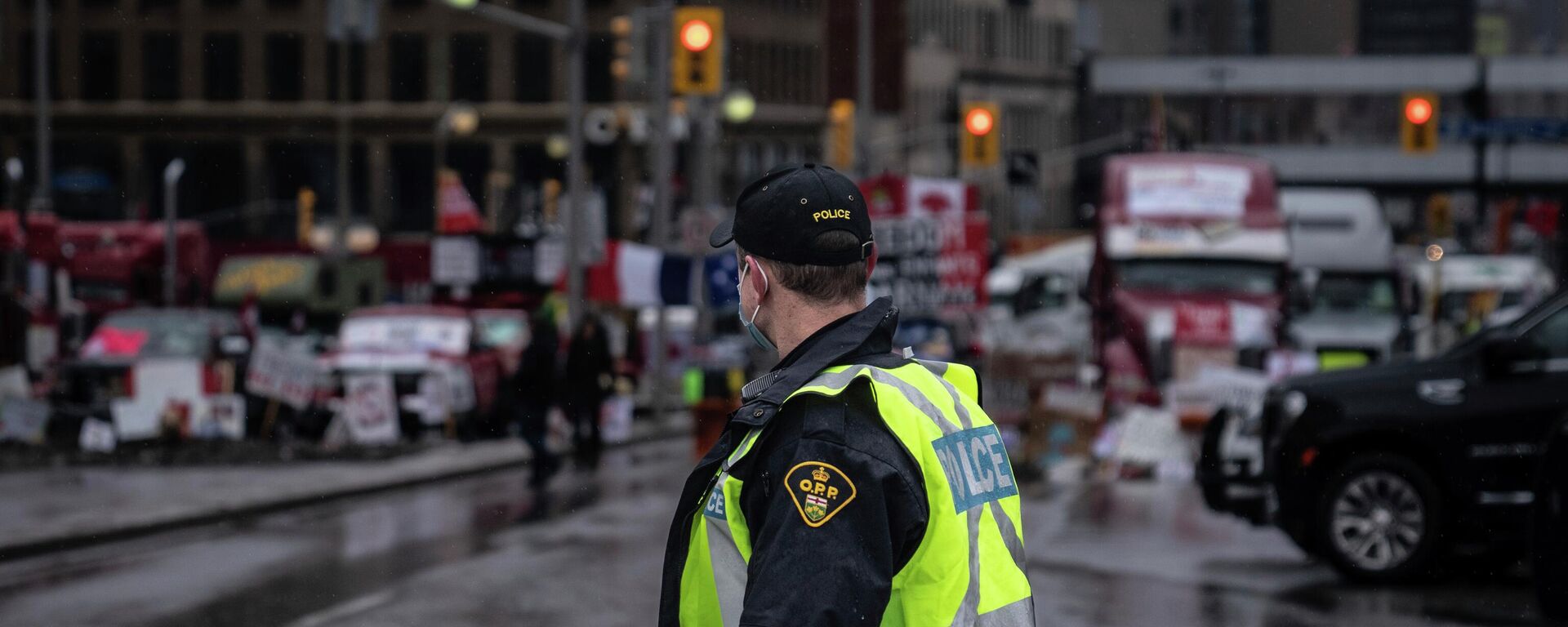 An Ontario Provincial Police officer walks in front of a row of trucks parked on the street near the Canadian parliament building in Ottawa on Thursday, Feb. 17, 2022. (AP Photo/Robert Bumsted) - Sputnik India, 1920, 19.06.2023