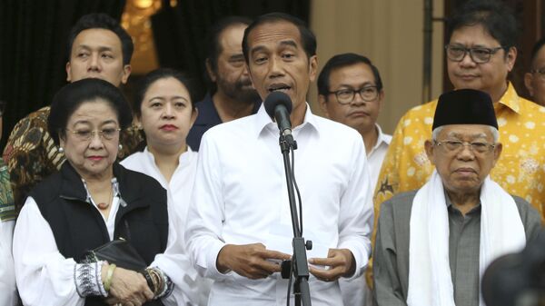 Incumbent Indonesian President Joko Widodo, center, delivers a speech as his running mate Ma'ruf Amin, right, Chairwoman of Indonesian Democratic Party-Struggle Megawati Sukarnoputri, left, and Chairman of Golkar Party Airlangga Hartarto, rear right, listen during a press conference after a coalition parties meeting in Jakarta, Indonesia, Thursday, April 18, 2019. - Sputnik India