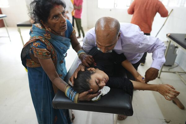A father tries to pacify his daughter suffering from heat related ailment as she is brought to the government district hospital in Ballia, Uttar Pradesh state, India, Monday, June 19, 2023. - Sputnik India