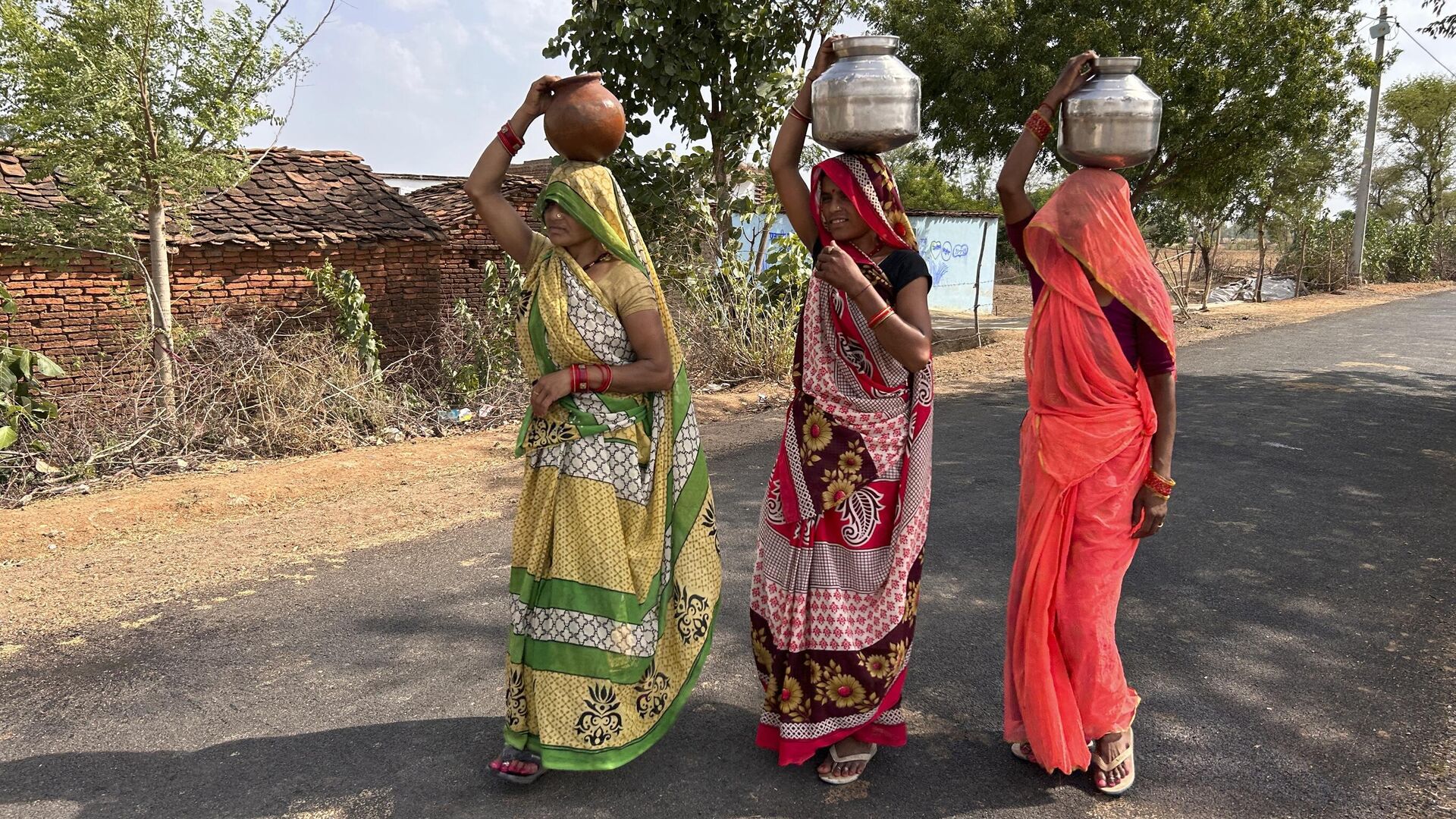 Women walk as they carry pitchers filled with drinking water on a hot summer afternoon in Lalitpur,  Uttar Pradesh state, India, Saturday, June 17, 2023. - Sputnik India, 1920, 07.09.2023