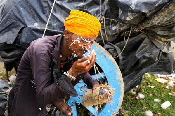 एक व्यक्ति ने अपने चेहरे पर पानी के छींटे मारते हुए (AP Photo/Rajesh Kumar Singh) - Sputnik भारत