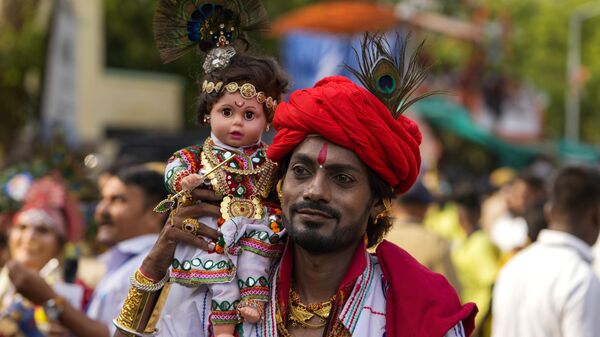 A man walks carrying a doll dressed as a Hindu deity during the annual chariot festival of Hindu god Lord Jagannath in Ahmedabad, India, Tuesday, June 20, 2023. - Sputnik India