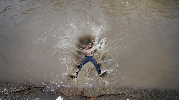 A boy jumps into a canal on a hot day in Jammu, India, Tuesday, June 20, 2023. Many parts of India are experiencing scorching heat this summer. - Sputnik India