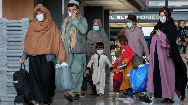 Families evacuated from Kabul, Afghanistan walk through the terminal to board a bus after they arrived at Washington Dulles International Airport, in Chantilly, Va., Sept. 1, 2021. - Sputnik India