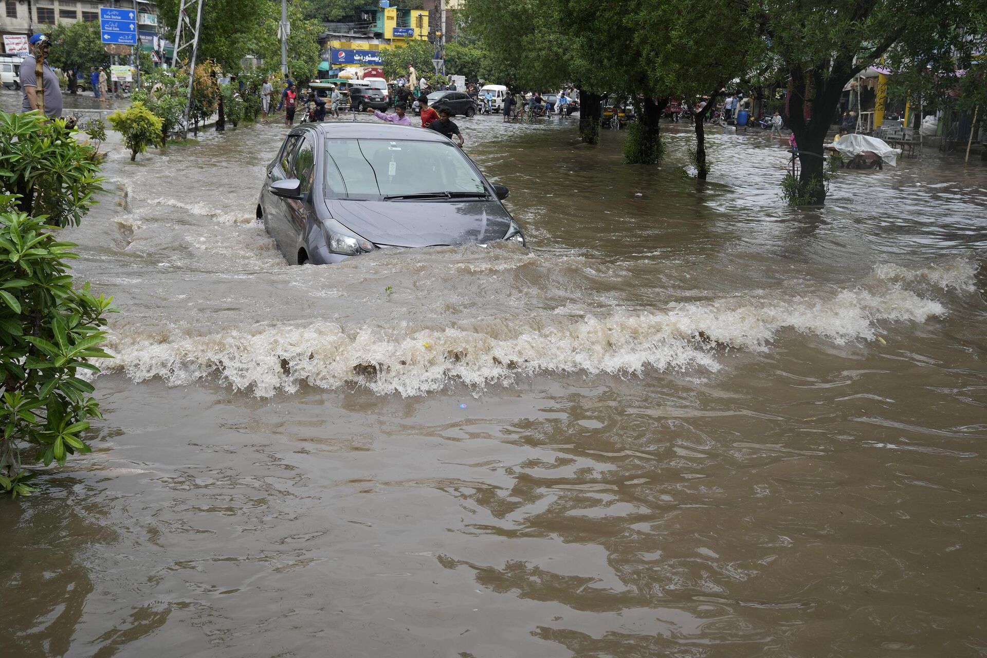 Автомобиль проезжает по затопленной дороге, вызванной проливными дождями, в Лахоре, Пакистан - Sputnik India, 1920, 08.09.2023