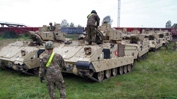 Members of the US Army 1st Brigade, 1st Cavalry Division, unload Bradley Fighting Vehicles at the railway station near the Rukla military base in Lithuania, on October 4, 2014 - Sputnik भारत