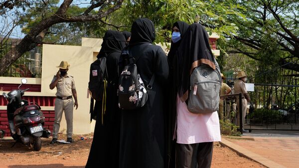 An Indian Muslim student wearing school uniform and hijab listens to fellow students wearing burqas after they were denied entry into the campus of Mahatma Gandhi Memorial college in Udupi, Karnataka state, India, Thursday, Feb. 24, 2022 - Sputnik India