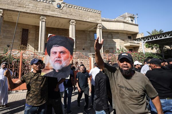 29 जून को शिया मुस्लिम नेता की तस्वीर लेकर विरोधकर्ता (Photo by Ahmad AL-RUBAYE / AFP) - Sputnik भारत
